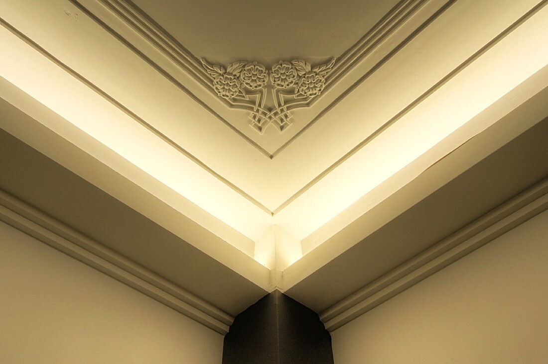 Detail of a decorative plaster ceiling corner with floral corbel motif
